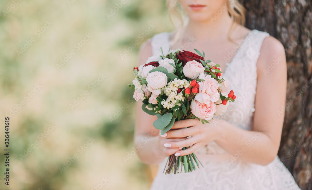 A beautiful bride is holding a wedding bouquet