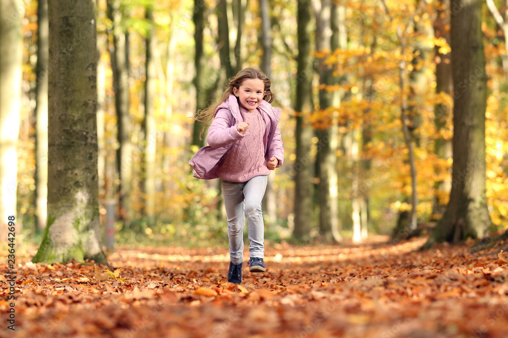 Kleines Mädchen rennt durch einen herbstlichen Wald Kleines Mädchen rennt durch einen herbstlichen Wald