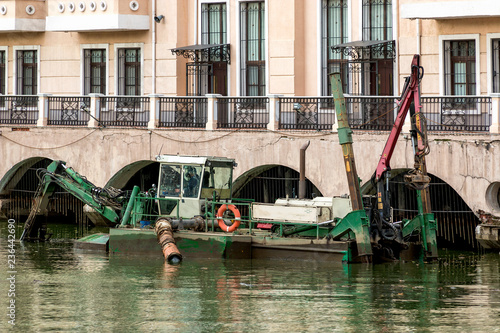 The dredger makes cleaning of the river bed in the place of formation of a pond. Russia exhibition center. Moscow. Russian Federation.