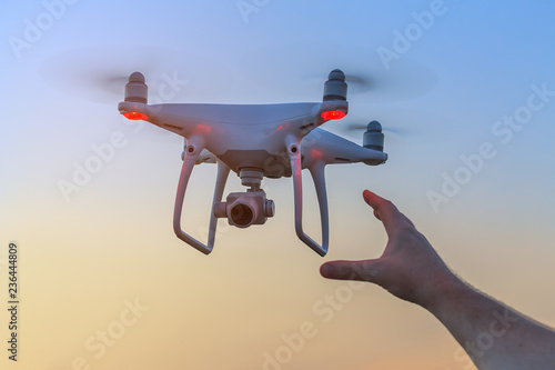 man reaches for the flying drone / you always want your core to land softer photo