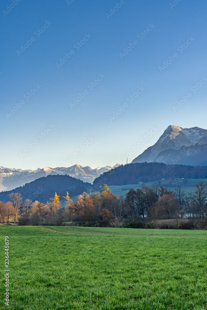Blick auf den Amsoldingersee und die Schweizer Alpen im Licht der Abendsonne – Berner Oberland, Panorama Berner Alpen, Schweiz Blick auf den Amsoldingersee und die Schweizer Alpen im Licht der Abendsonne – Berner Oberland, Panorama Berner Alpen, Schweiz
