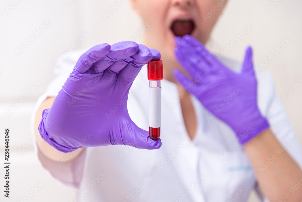 Obraz premium Scared woman holding blood sample tube