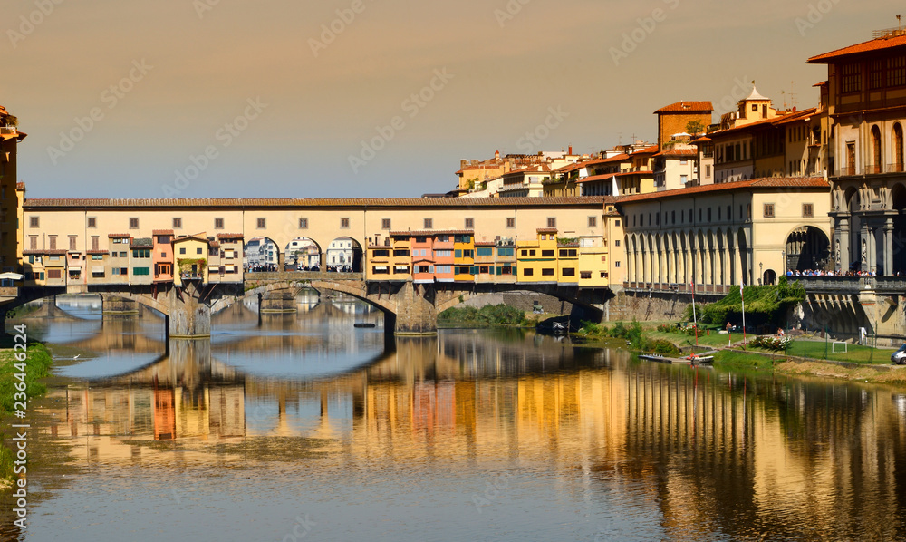 The famous old bridge (Ponte Vecchio) over Arno river in Florence at sunset. Italy