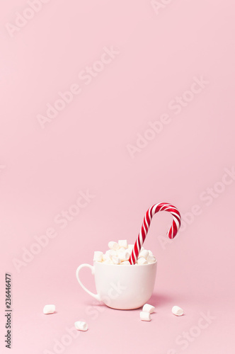 Christmas New Year drink, white mug with marshmallows and Candy Cane on pink background Flat Lay copy space. Winter traditional drink food. Festive decor, celebration Xmas holiday 2019