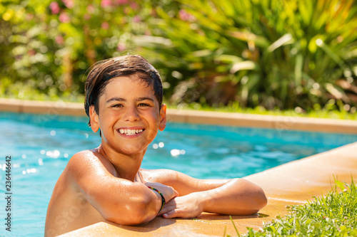 Smiling boy relaxing at outdoor swimming pool