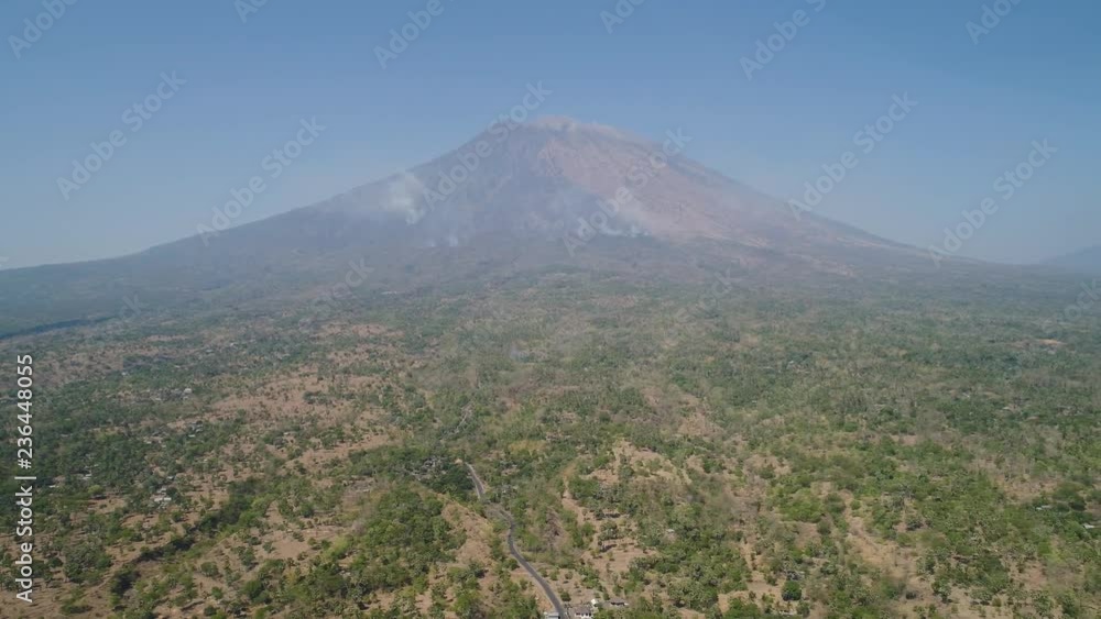 Aerial view slope mount Agung volcano with forest fire Bali, Indonesia. tropical landscape savanna with low trees at foot volcano. Rural mountain landscape. Aerial footage. Aerial view slope mount Agung volcano with forest fire Bali, Indonesia. tropical landscape savanna with low trees at foot volcano. Rural mountain landscape. Aerial footage.