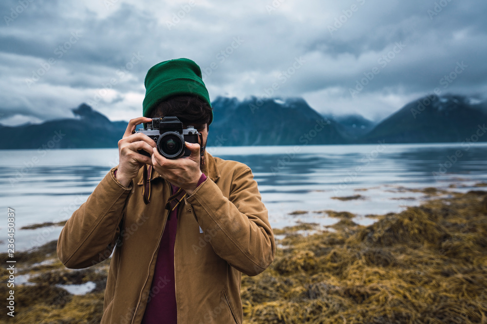 Young man with woolly hat taking pictures with camera Young man with woolly hat taking pictures with camera