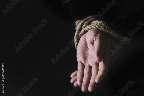 man with his hands tied behind his back photo