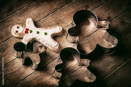 Christmas gingerbread man cookie with baked forms on wooden background