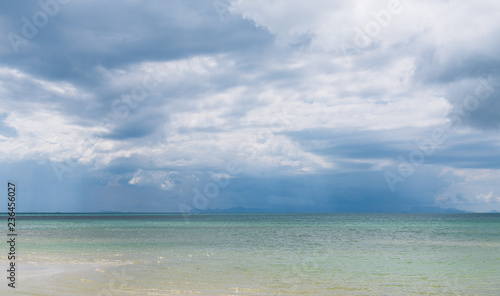 Rain clouds over beautiful tropical beach seascape in summer season