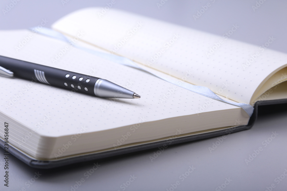 black stylish notebook and ballpoint pen on the office desk. black stylish notebook and ballpoint pen on the office desk.