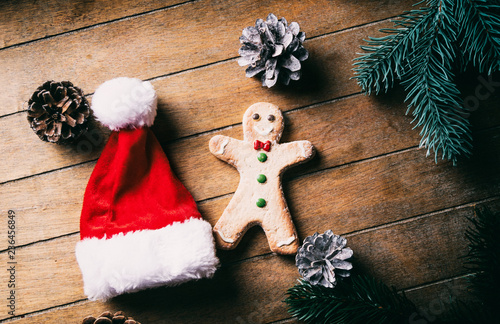 Hight angle view on ginbgerbread man cookie and Santa Claus hat on wooden background