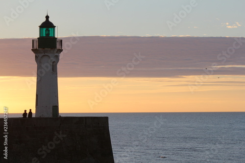 lighthouse in the evening with orange and purple colors in the sky
