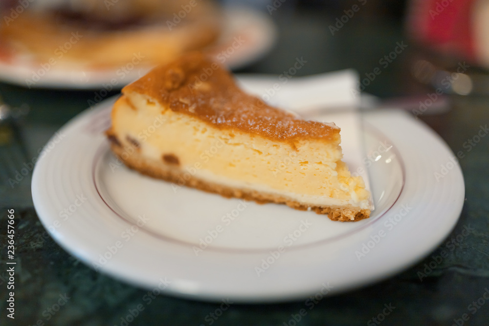 Ein Stück Käsekuchen auf einem weißen Teller Ein Stück Käsekuchen auf einem weißen Teller