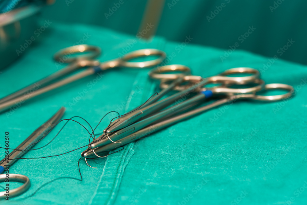 Needle holders with needles and surgical instruments on operating table Needle holders with needles and surgical instruments on operating table