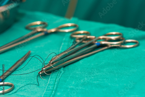 Needle holders with needles and surgical instruments on operating table