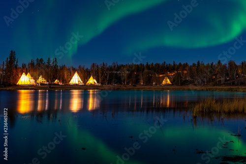 Light up Tipi  indian Tent  with water reflection during Aurora Borealis  Northern Light  at Yellow Knife 