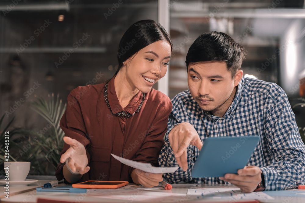 Dark-eyed husband having hesitations about business plan of his wife Dark-eyed husband having hesitations about business plan of his wife
