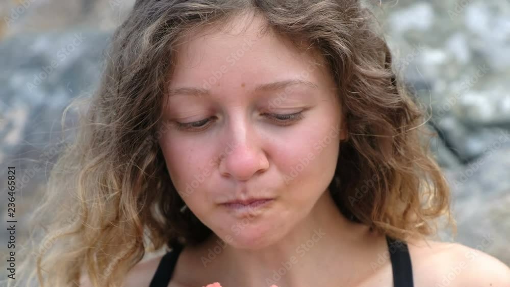 Portrait of a beautiful curly woman, bites off a watermelon close-up Portrait of a beautiful curly woman, bites off a watermelon close-up