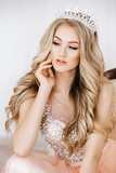 Portrait of beautiful blonde woman with makeup in fashion clothes and crown