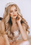 Portrait of beautiful blonde woman with makeup in fashion clothes and crown