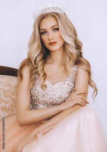 Portrait of beautiful blonde woman with makeup in fashion clothes and crown