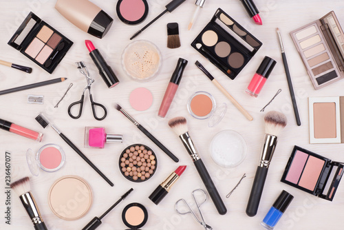 Makeup cosmetics such as eyeshadows, lipstick, mascara and other on white, wooden background, top view