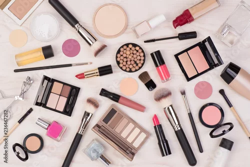 Fototapeta na wymiar Makeup cosmetics such as eyeshadows, lipstick, mascara and makeup accessories on white, wooden background, top view