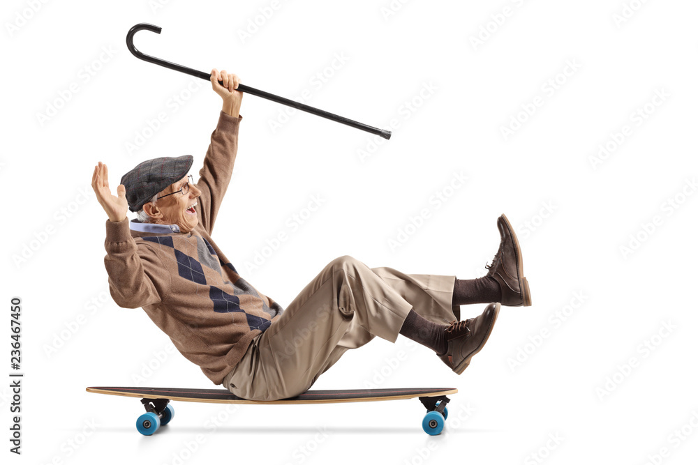 Cheerful senior with a cane sitting on a longboard and riding - obrazy, fototapety, plakaty 