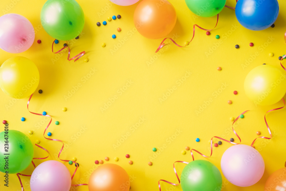 Heap of colorful balloons, confetti and candies on yellow table top view.  Birthday party background. Festive greeting card. Stock Photo | Adobe Stock