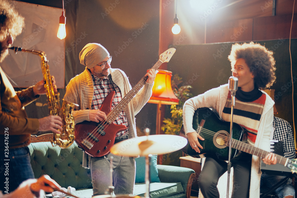 Fototapeta premium Wielokulturowy zespół jazzowy ćwiczący do koncertu w domowym studio.