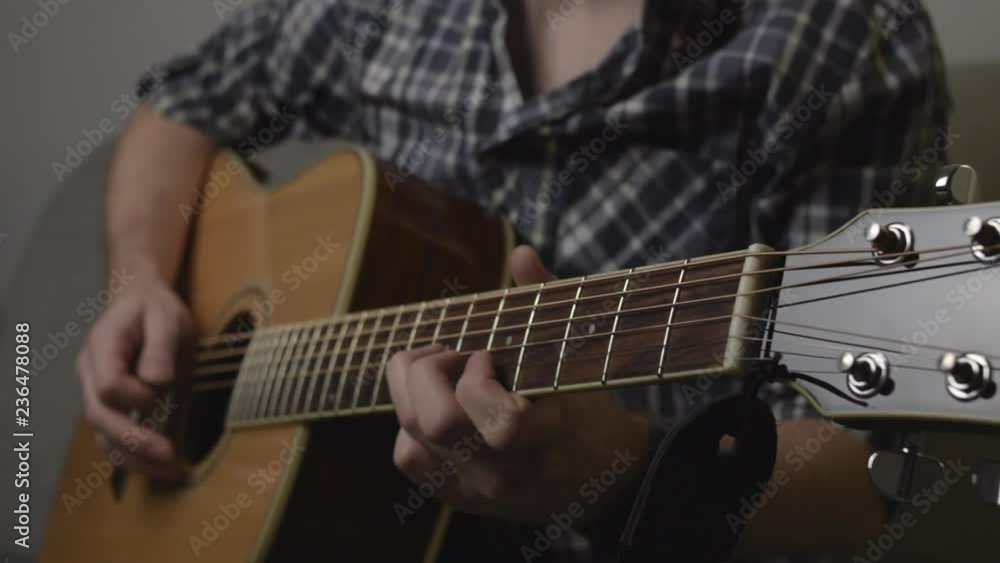 Man in shirt playing solo on acoustic guitar with pick slow motion full hd footage Man in shirt playing solo on acoustic guitar with pick slow motion full hd footage