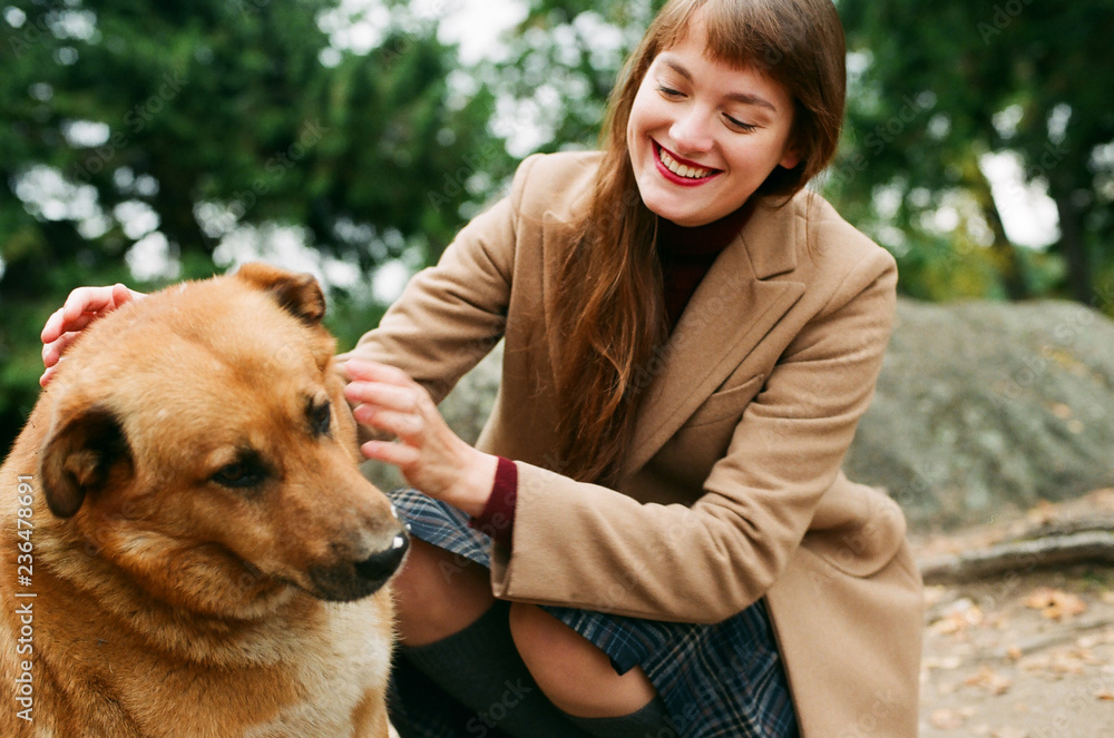 Young woman stroking homeless dog Young woman stroking homeless dog