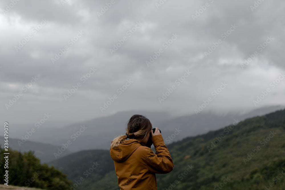 Young woman hiking through mountain and taking photographs Young woman hiking through mountain and taking photographs