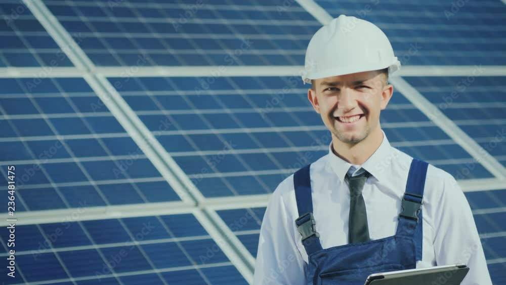Portrait of a successful young engineer on the background of a solar power station Portrait of a successful young engineer on the background of a solar power station
