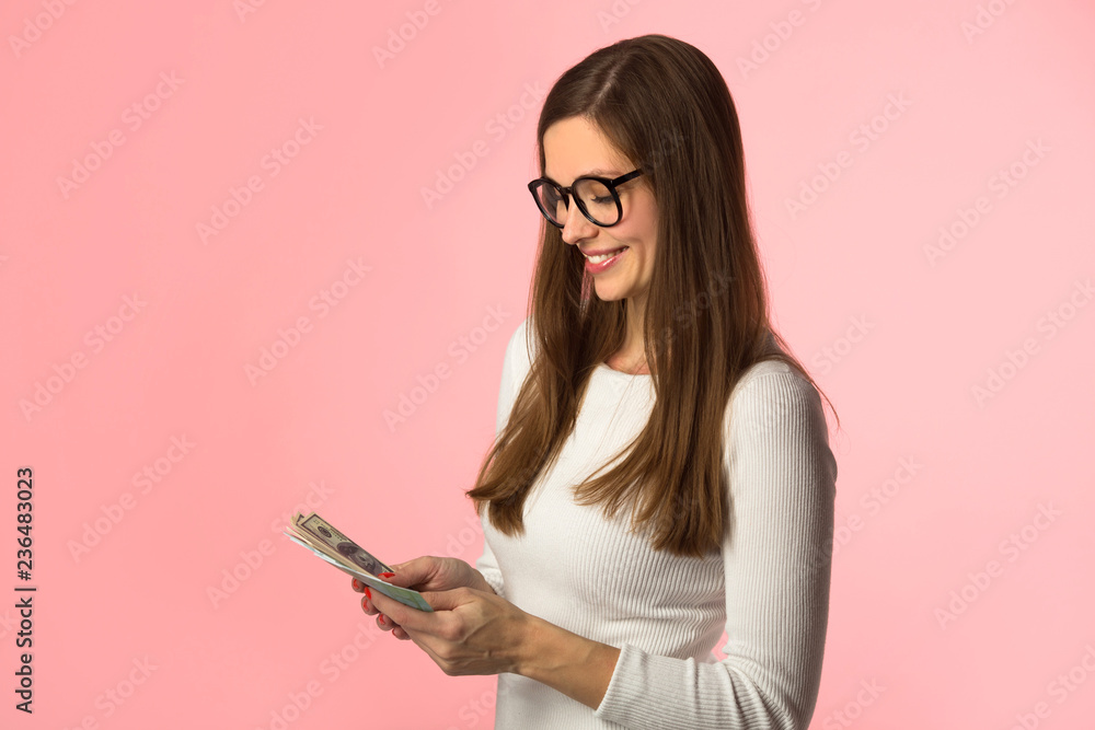 beautiful young girl in glasses with dollars and euros in her hands on a pink background beautiful young girl in glasses with dollars and euros in her hands on a pink background