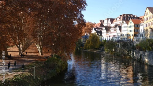 View from a bridge in Tuebingen on the river, an ally and some half-timbered houses in Germany during autumn pan right photo