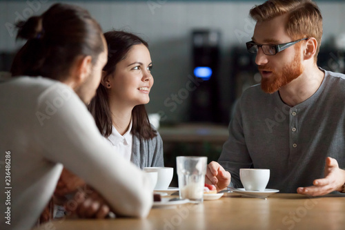Diverse friends meeting in coffeeshop talking at table, happy students have fun in cafe enjoying coffee spending time together, millennial work mates or colleagues hang out in cafeteria during break