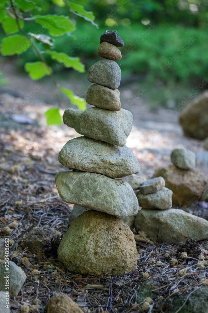 Stone man landart, sandstone stones high tower, harmony and balance, stone man on the path Stone man landart, sandstone stones high tower, harmony and balance, stone man on the path