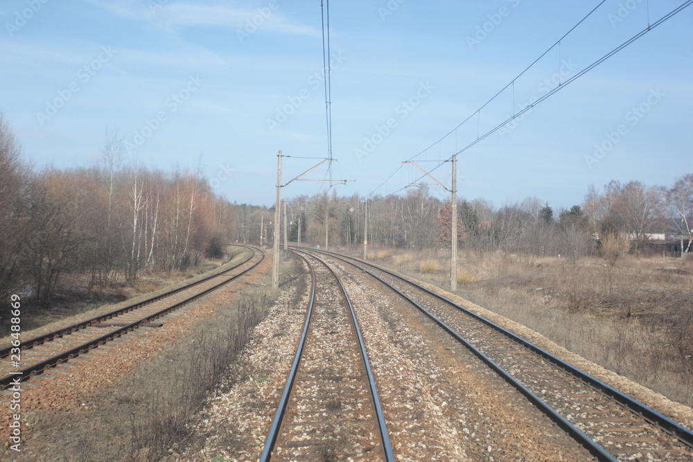 railroad, trucks and dry grass seen from the end of a train - wide angle photo in Poland, Europe
