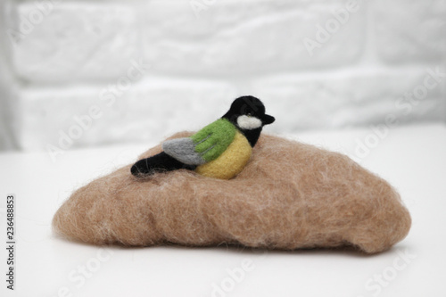 Wool felted bird on wool for felting
