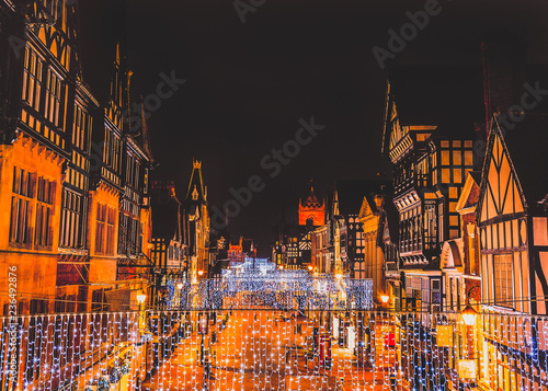 Eastgate Street Chester, UK at night with Christmas lights hanging from the impressive Tudor black and white buildings photo