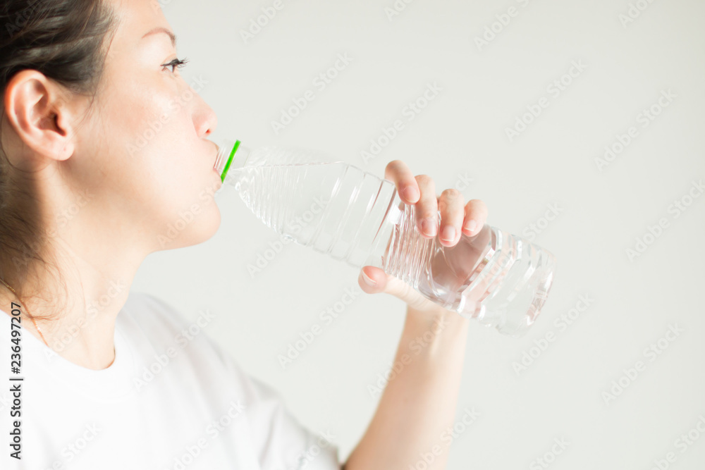 A woman drinking water from plastic bottle. A woman drinking water from plastic bottle.