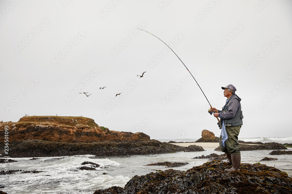 Portrait of retired man fishing at the ocean