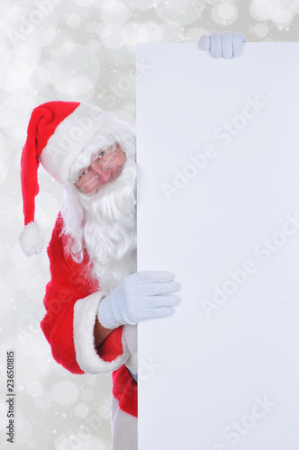 Santa Claus peeking out from behind a large balnk sign © Steve Cukrov