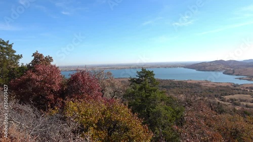 View of beautiful landscape with lake and autumn colors of wild growing trees and brush. View from Wichita Mountains.