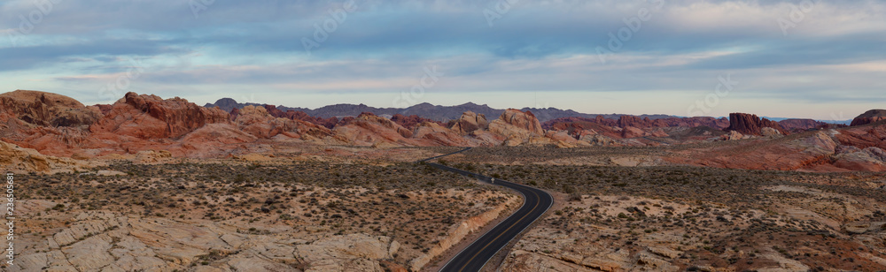 Aerial panoramic view on the scenic road in the desert during a cloudy sunrise. Taken in Valley of Fire State Park, Nevada, United States.