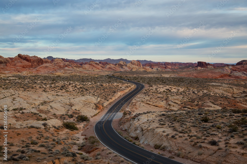 Aerial view on the scenic road in the desert during a cloudy sunrise. Taken in Valley of Fire State Park, Nevada, United States.