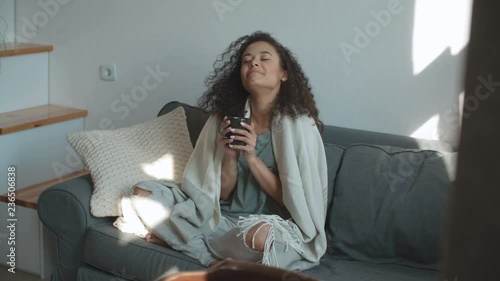 Portrait of smiling woman drinking coffee or tea at home.