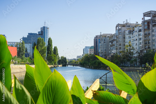 Dambovita river in downtown Bucharest; residential and office buildings on its shoreline, Romania